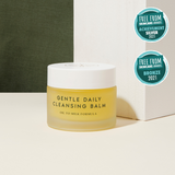 frosted jar with white lid with the words Gentle Daily Cleansing Balm Oil to milk formula printed on the jar with yellow best cleansing balm for sensitive skin inside
